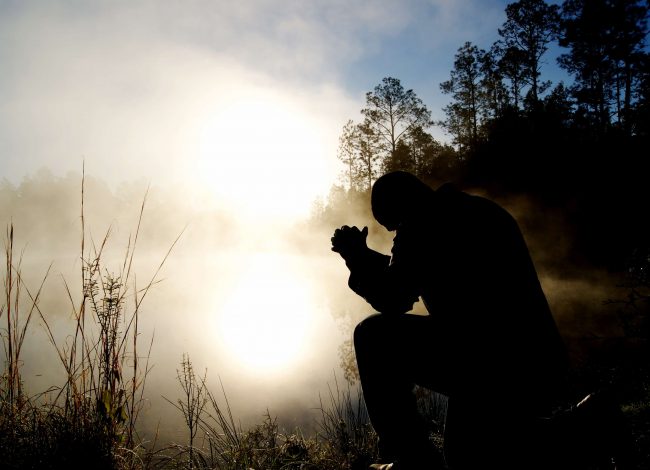 Person kneeling in prayer