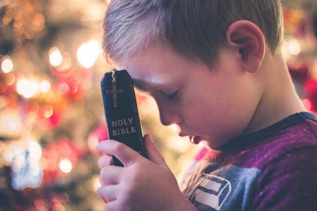 Praying boy with Bible