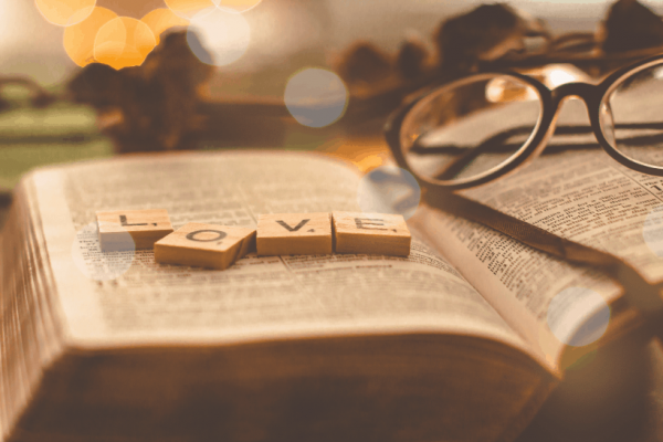 Love spelled with Scrabble tiles on Bible