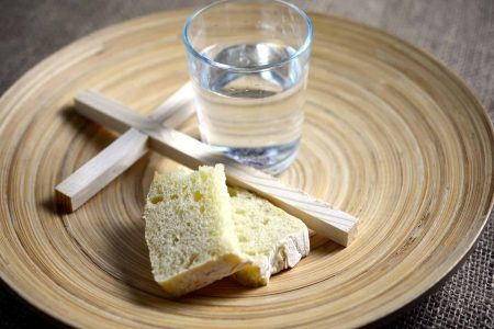 bread, water and cross on a plate