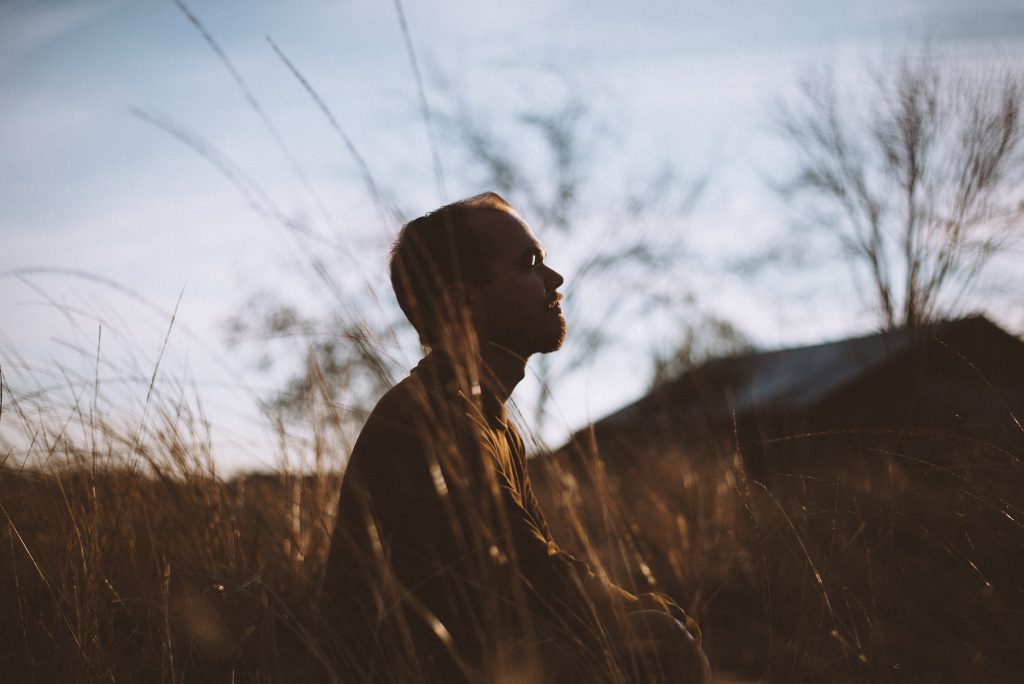 man meditating in field