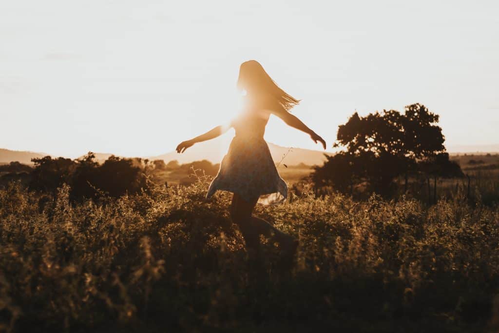 woman twirling in field