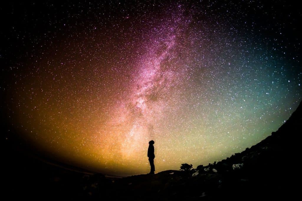 man looking up at milky way galaxy