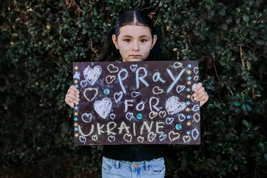 child holding sign, "pray for ukraine"