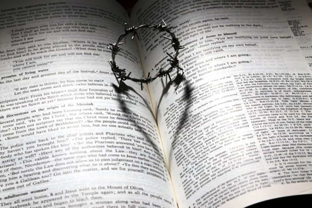 Crown of thorns casting a heart-shaped shadow on Bible pages